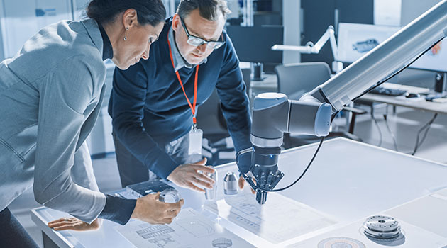 Female engineer and male specialist talking learn on the table